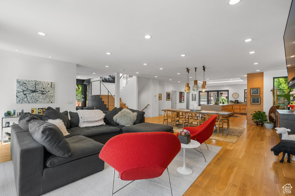 Living area featuring light wood finished floors, recessed lighting, and stairway