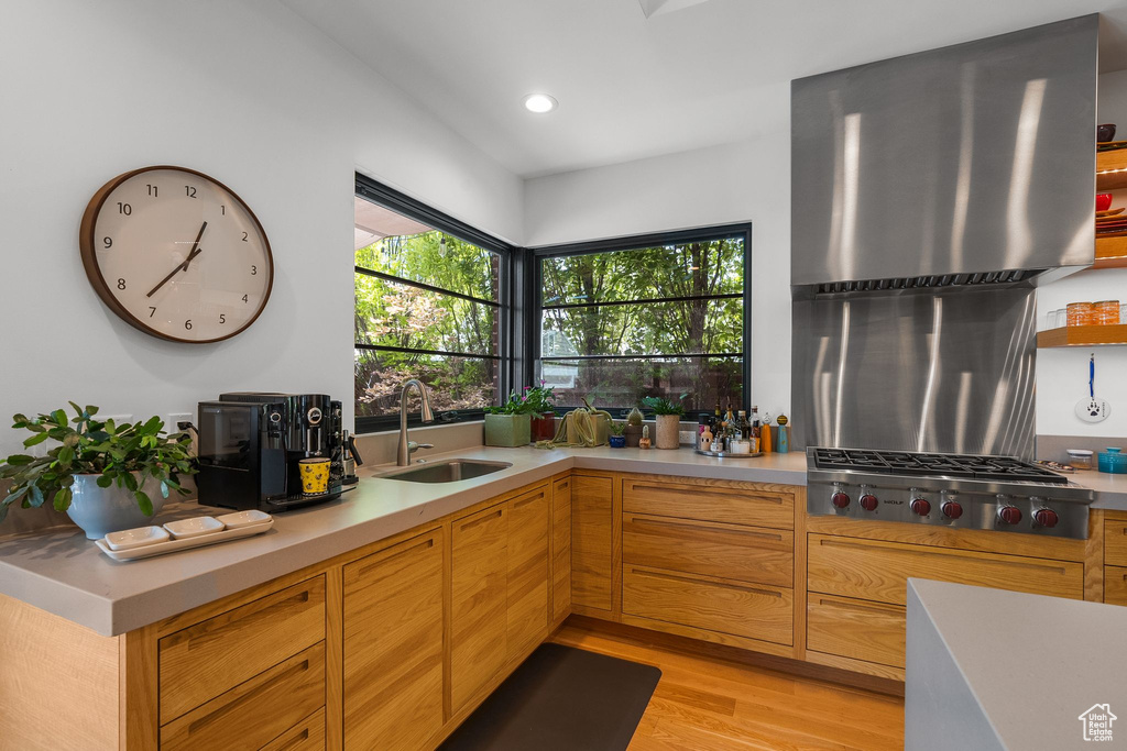 Kitchen featuring a sink, light countertops, light wood-type flooring, stainless steel gas stovetop, and recessed lighting