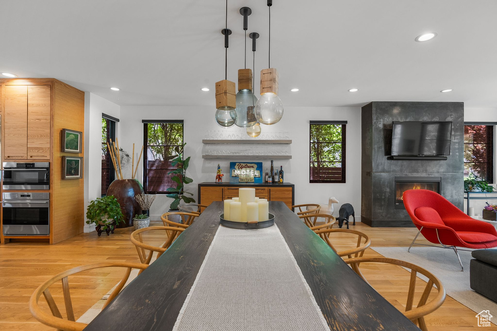 Dining area with a fireplace, light wood finished floors, and recessed lighting