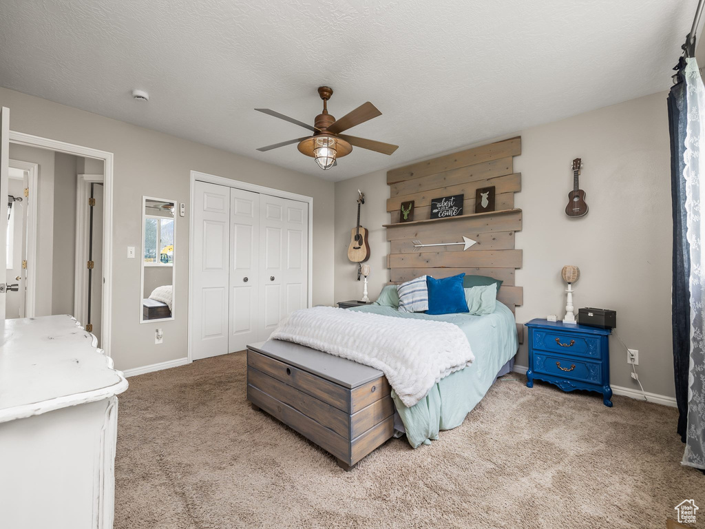 Bedroom with carpet flooring, a closet, baseboards, and a ceiling fan