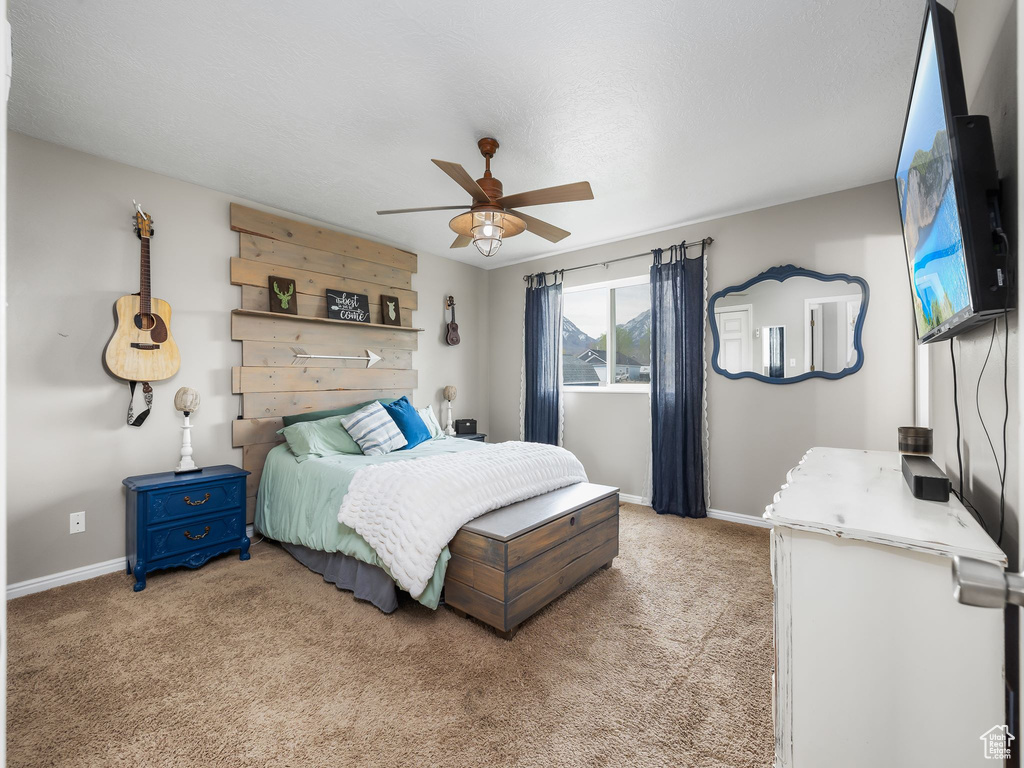 Bedroom with light carpet, baseboards, and ceiling fan