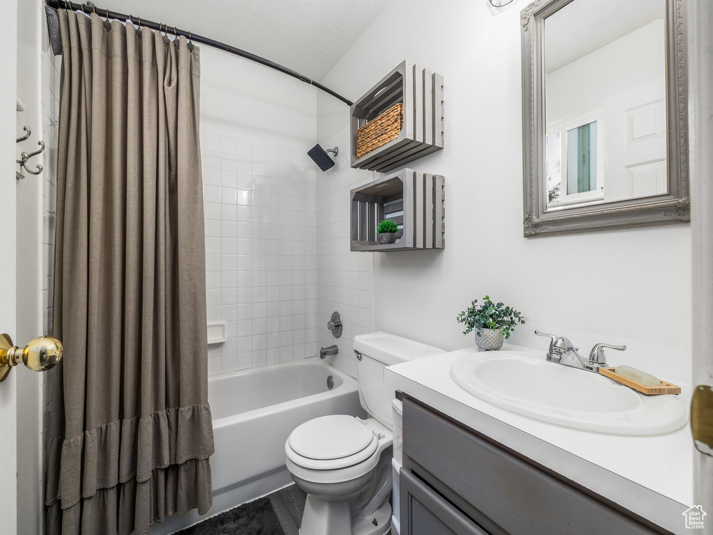 Full bathroom with toilet, shower / tub combo, and vanity