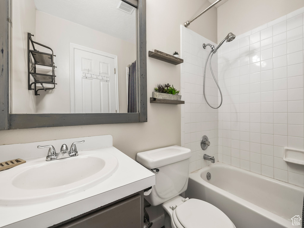 Bathroom with toilet, vanity, and washtub / shower combination