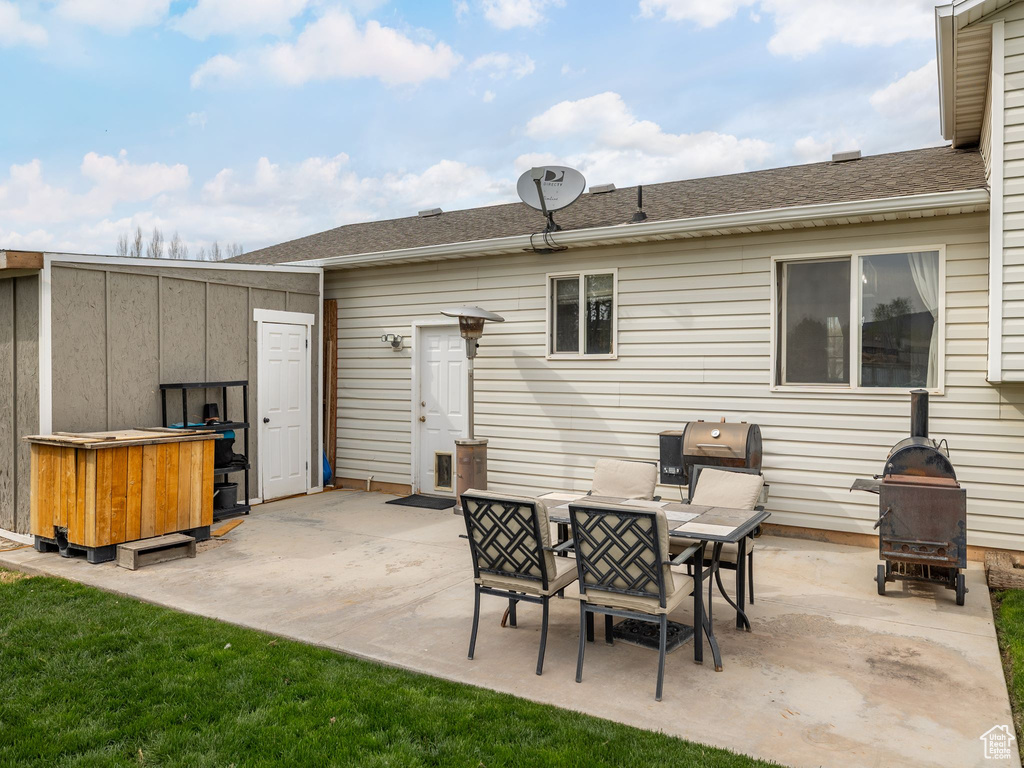 Back of property featuring a patio area and a shingled roof