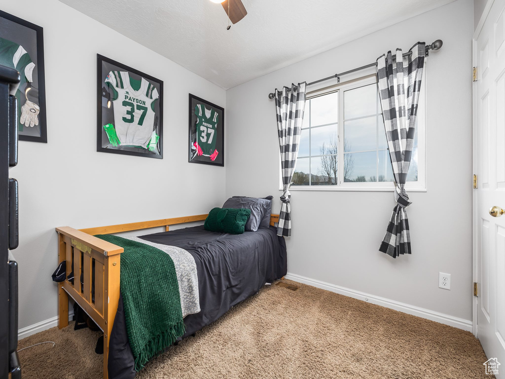 Carpeted bedroom with baseboards and a ceiling fan