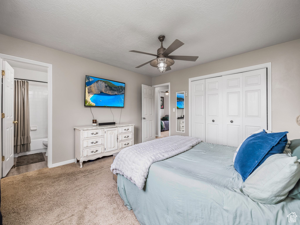 Bedroom featuring baseboards, a closet, ceiling fan, light colored carpet, and connected bathroom