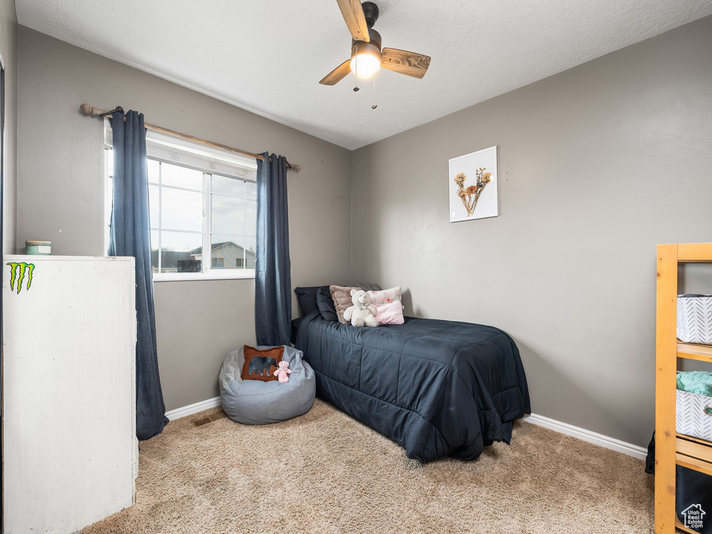 Carpeted bedroom with baseboards and ceiling fan