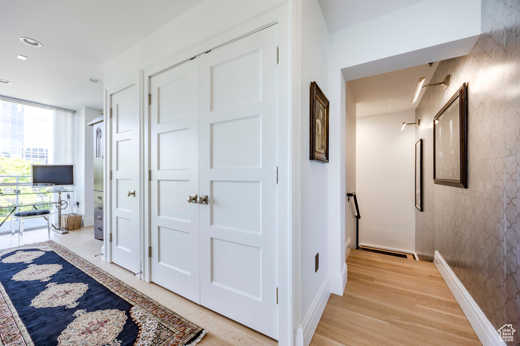 Hallway with light wood-style floors and baseboards