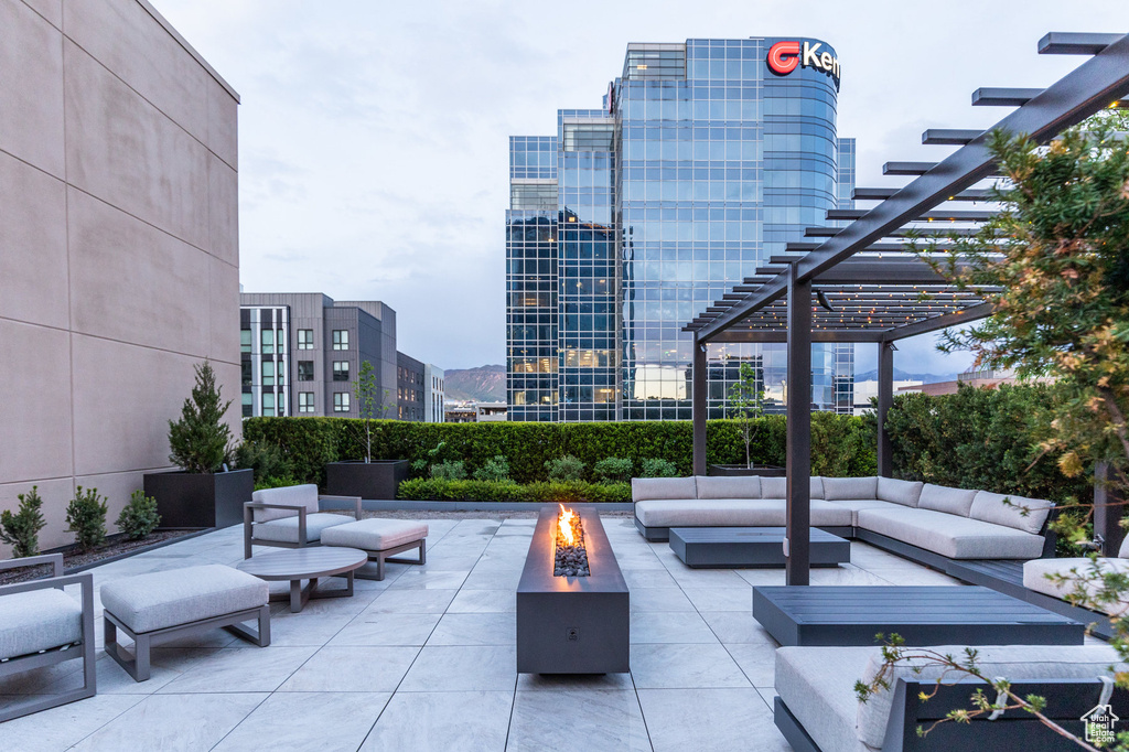 View of patio with an outdoor living space with a fire pit, a pergola, and a view of city
