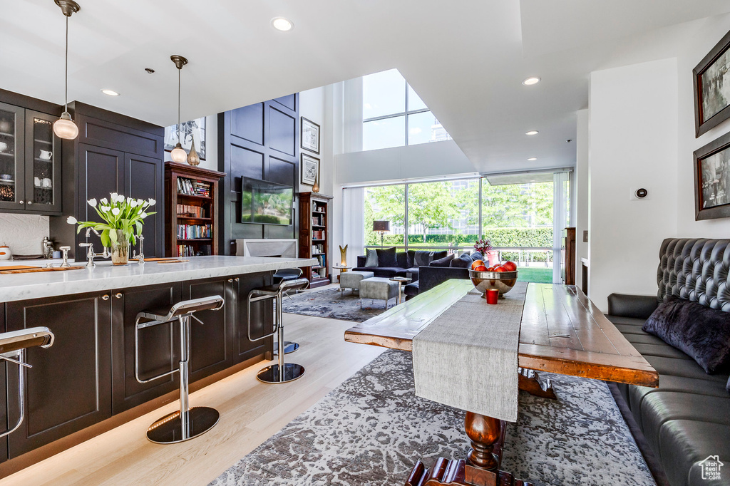 Living area featuring wood finished floors, recessed lighting, and a high ceiling