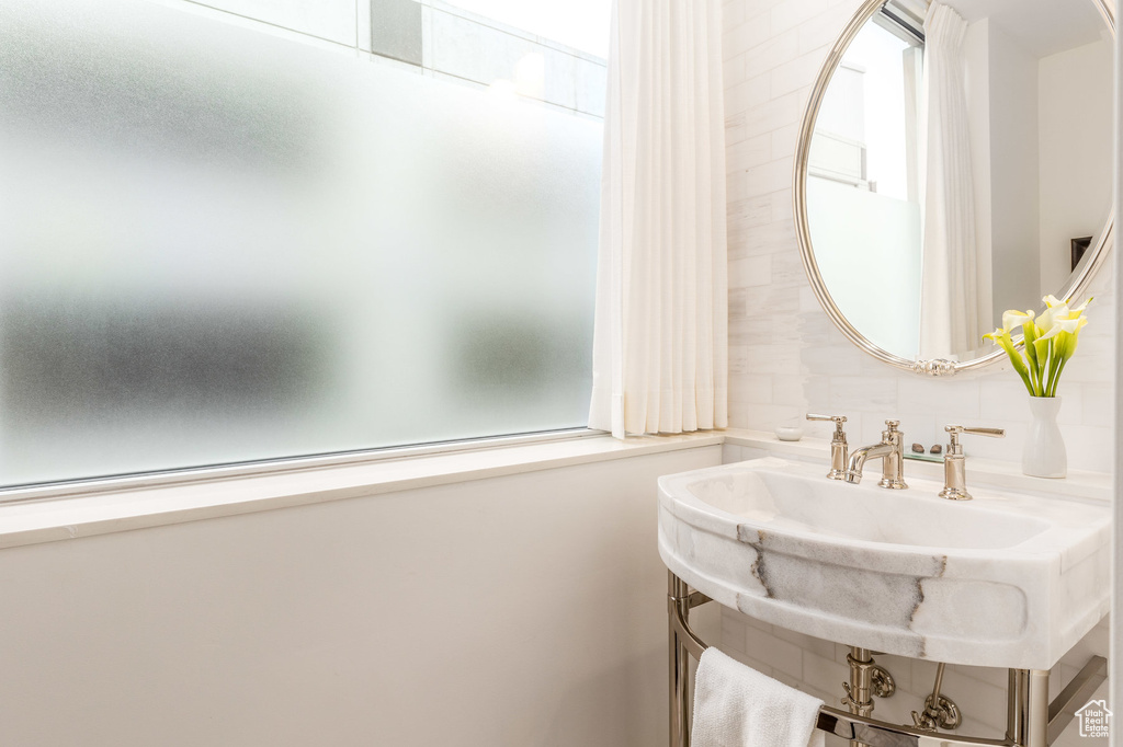 Bathroom featuring decorative backsplash and a sink