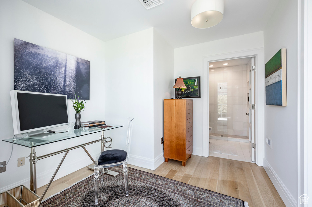 Home office with baseboards and wood finished floors