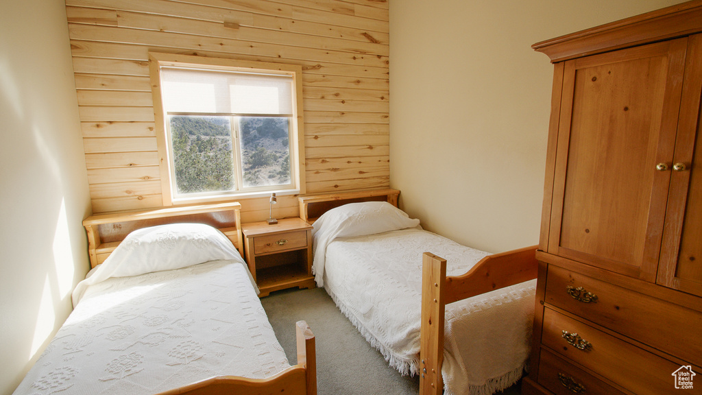 Bedroom featuring carpet floors and wood walls