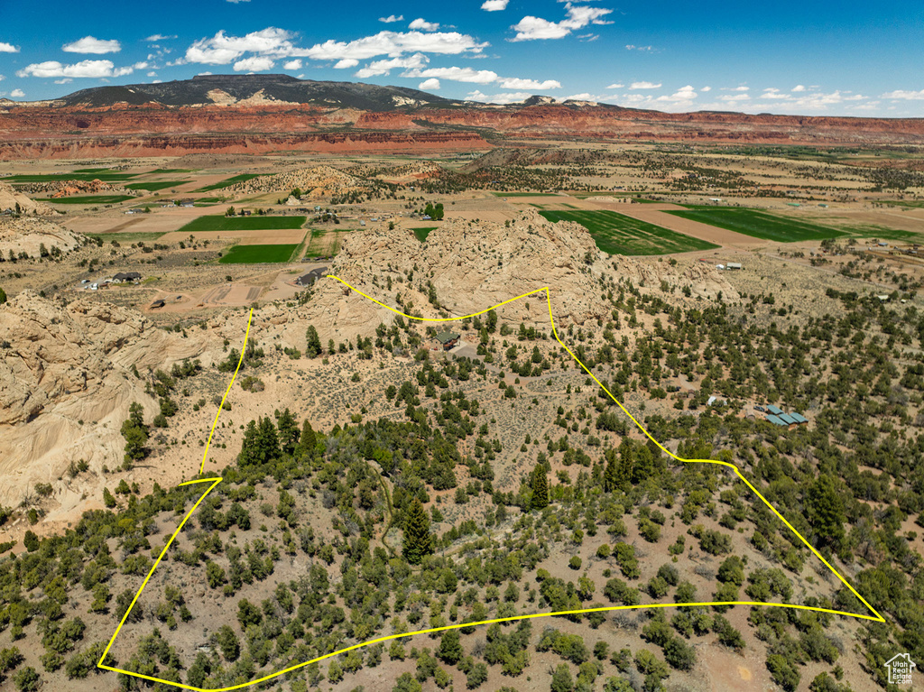 Aerial view of sparsely populated area with property parcel outlined, mountains, and a desert landscape