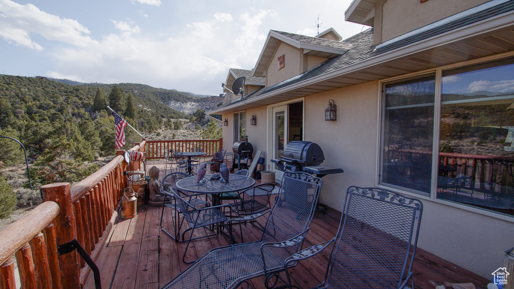Deck with outdoor dining area and a mountain view