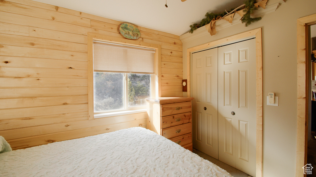 Bedroom with wood walls and a closet