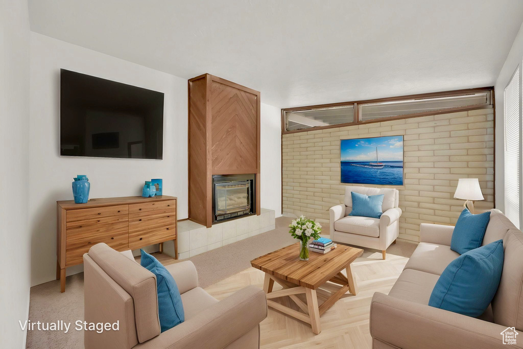 Living area featuring a glass covered fireplace and brick wall
