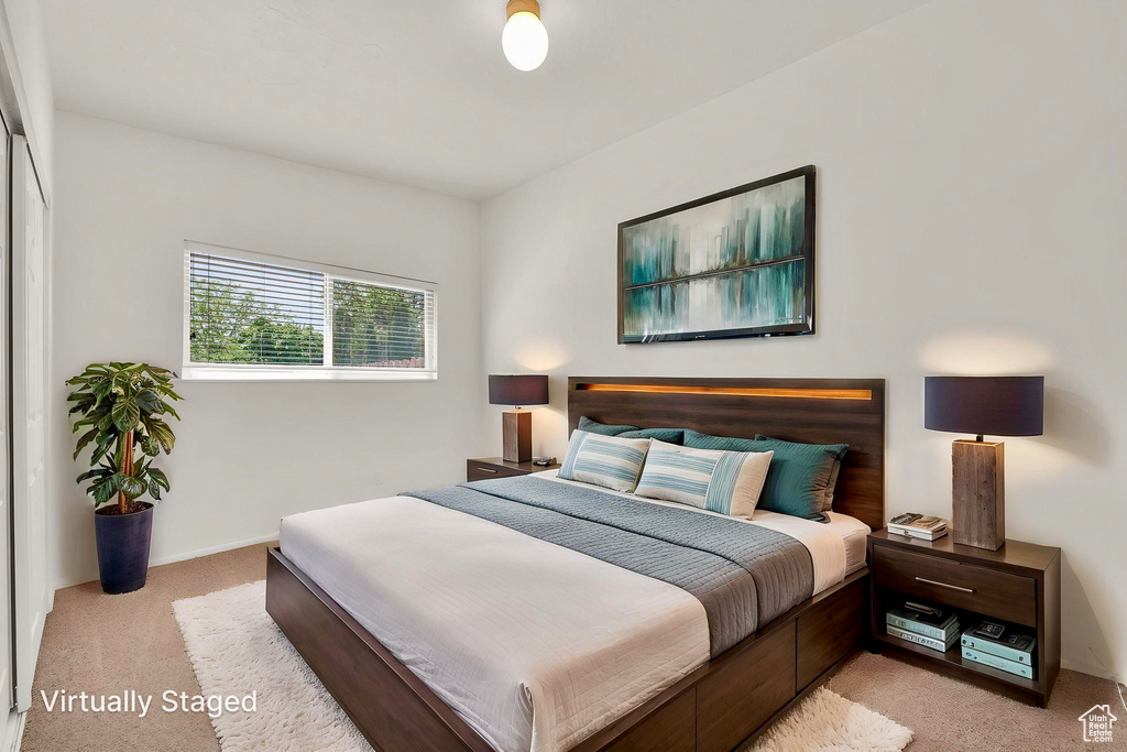 Bedroom featuring light carpet and baseboards