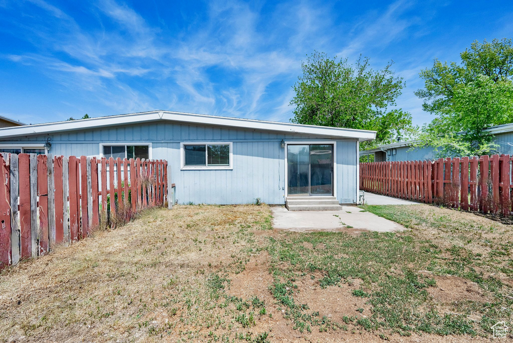Rear view of house featuring a fenced backyard and entry steps