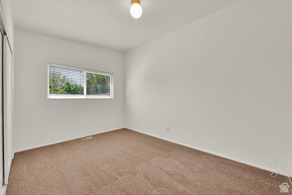 Carpeted empty room featuring baseboards
