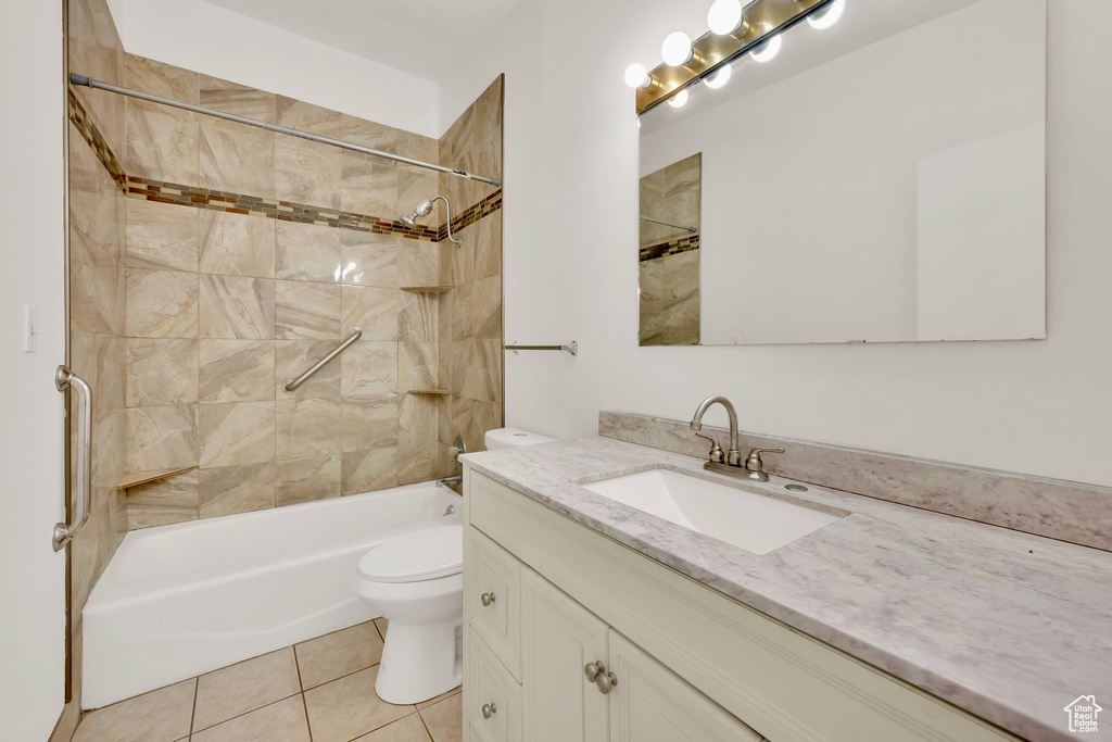 Bathroom featuring toilet, vanity, bathing tub / shower combination, and tile patterned flooring