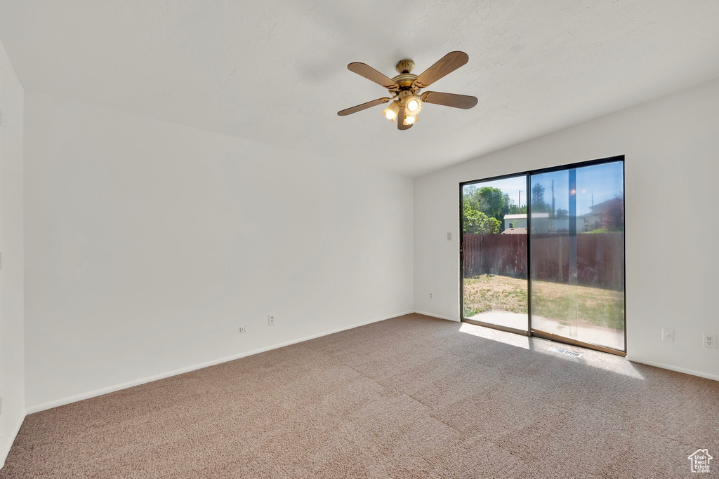 Spare room featuring carpet, ceiling fan, and baseboards