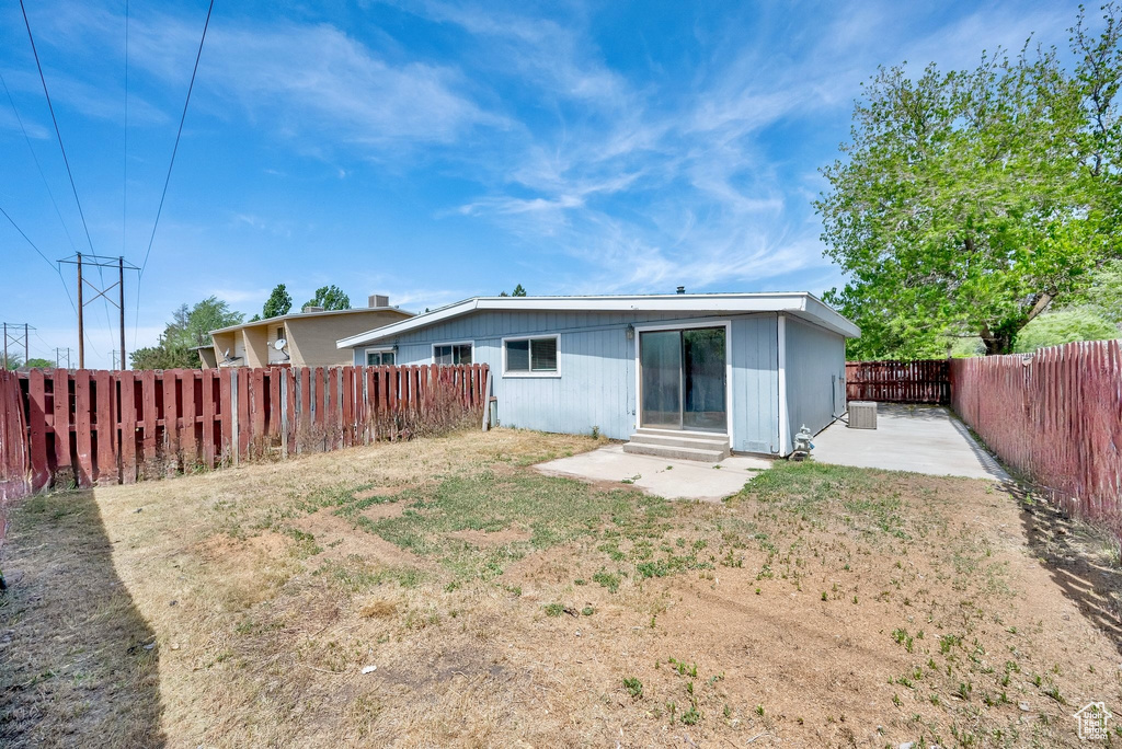 Rear view of property featuring a patio area, a fenced backyard, and entry steps