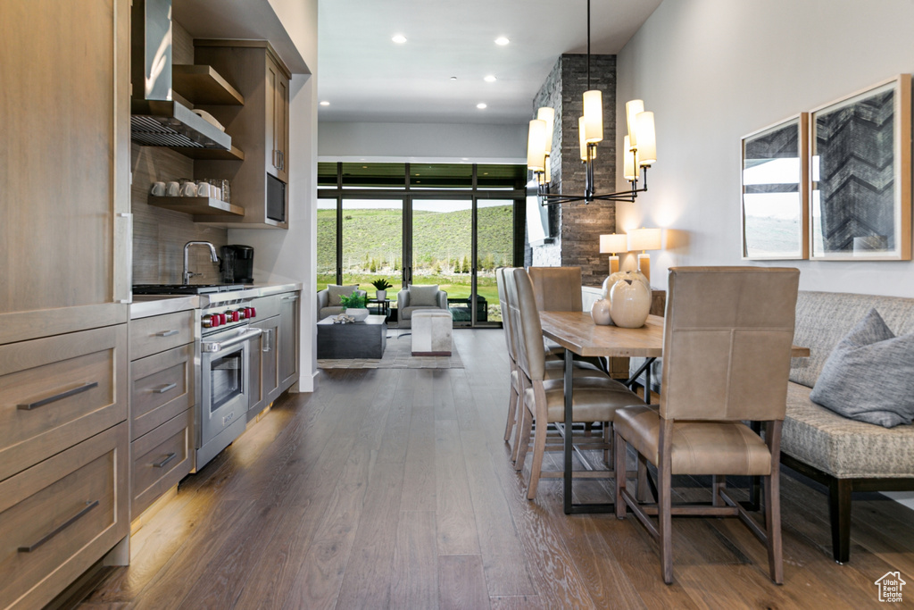 Dining room with dark wood-type flooring, a chandelier, and recessed lighting