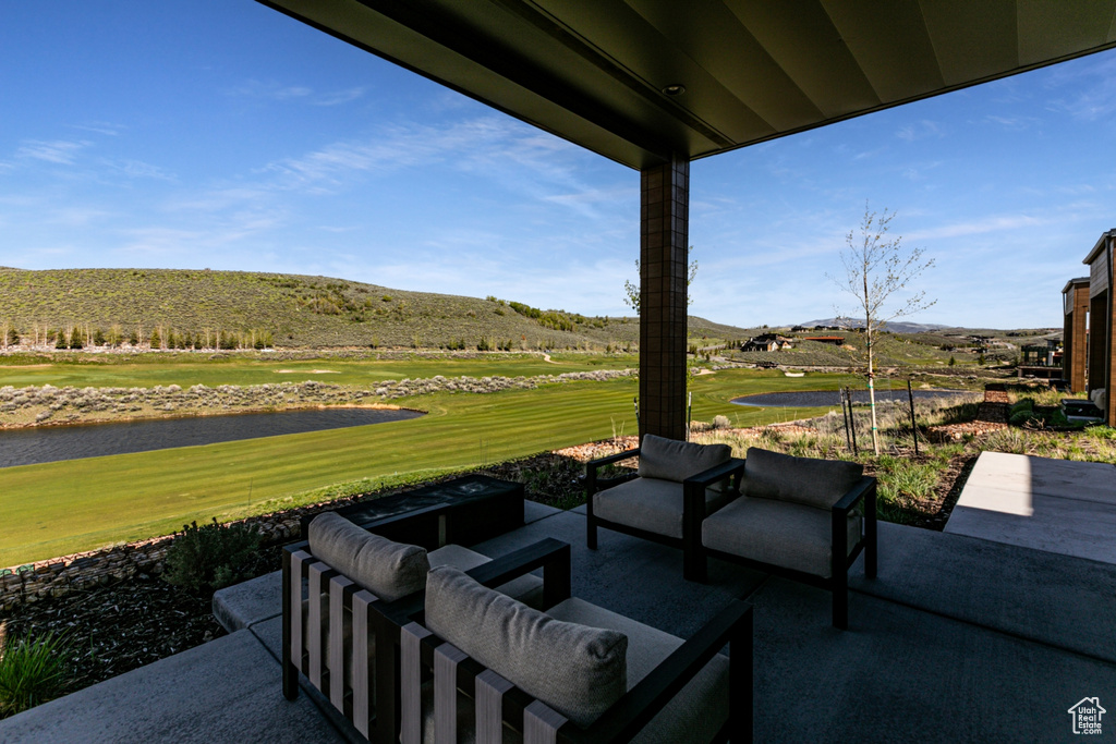 View of patio / terrace featuring outdoor lounge area, view of golf course, and a water and mountain view