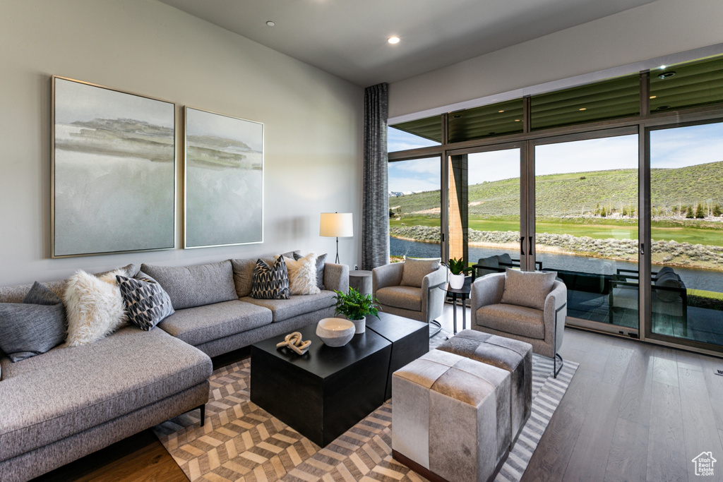 Living room with wood finished floors, recessed lighting, and a water view