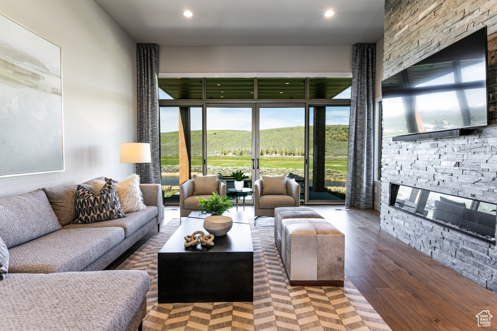 Living room featuring a fireplace, plenty of natural light, recessed lighting, and wood finished floors