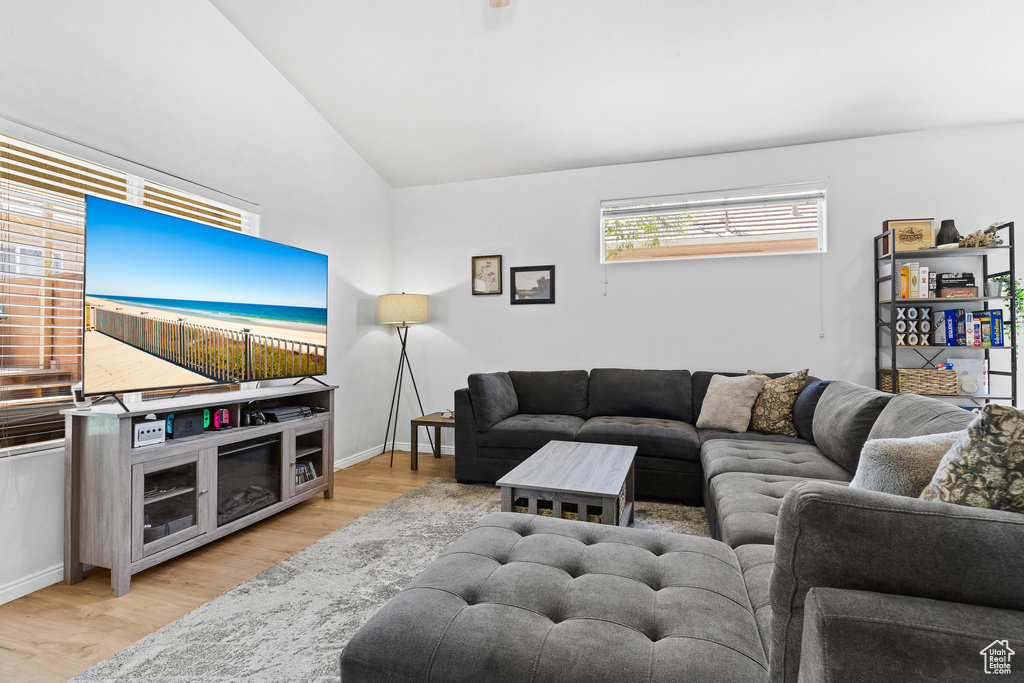 Living area with lofted ceiling, wood finished floors, and baseboards