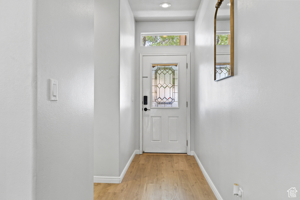 Doorway to outside featuring baseboards and light wood-style flooring