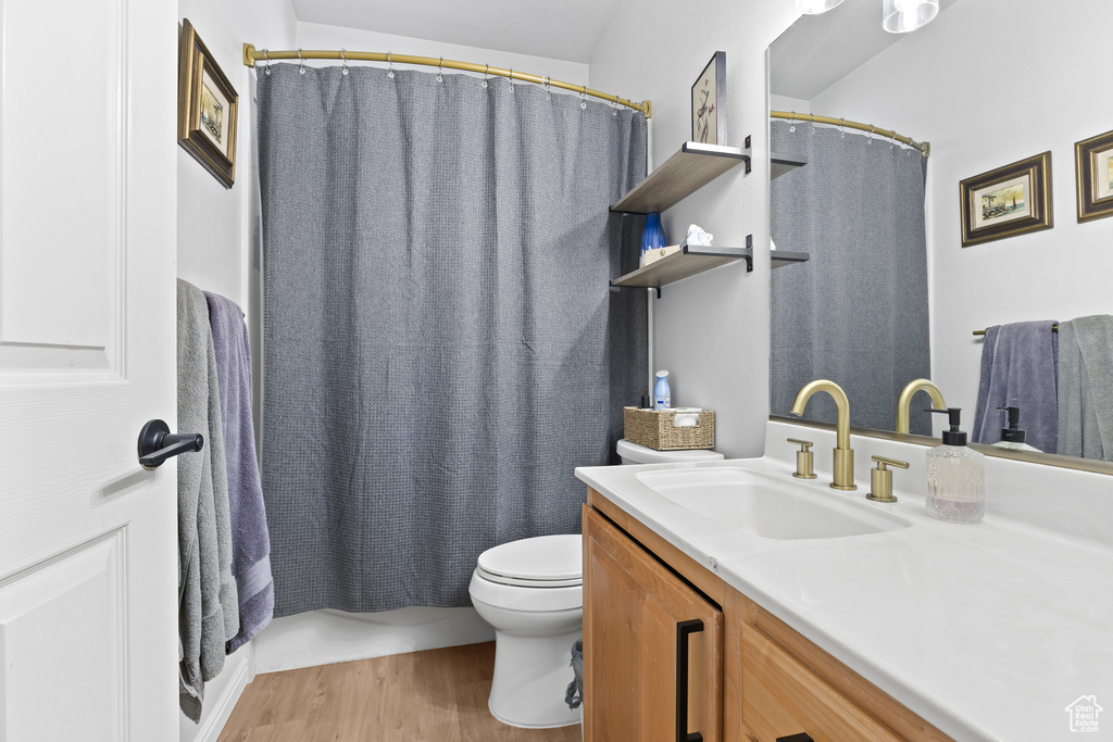 Full bath featuring wood finished floors, toilet, vanity, and a shower with curtain