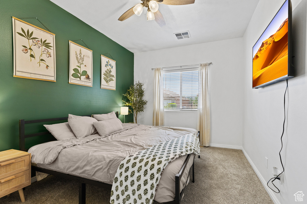 Carpeted bedroom featuring baseboards and ceiling fan