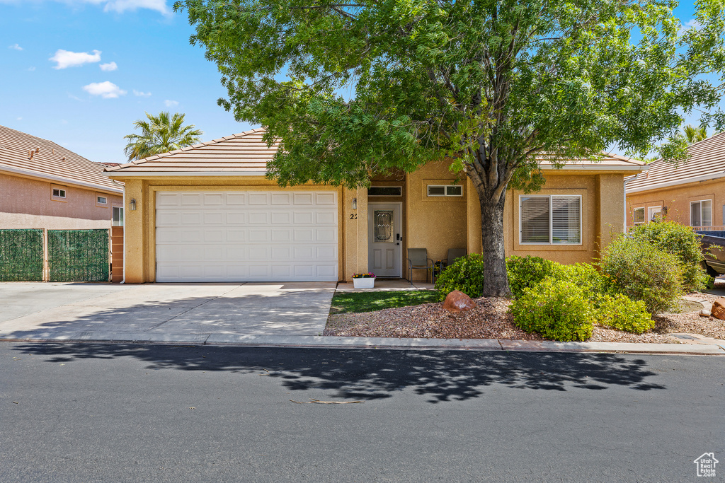 View of front of house with concrete driveway, stucco siding, and a garage