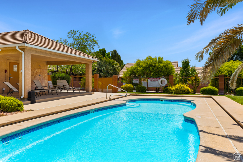 Community pool with a patio and fence