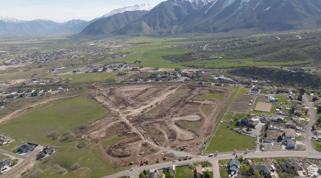 Aerial overview of property's location with a mountain backdrop and nearby suburban area