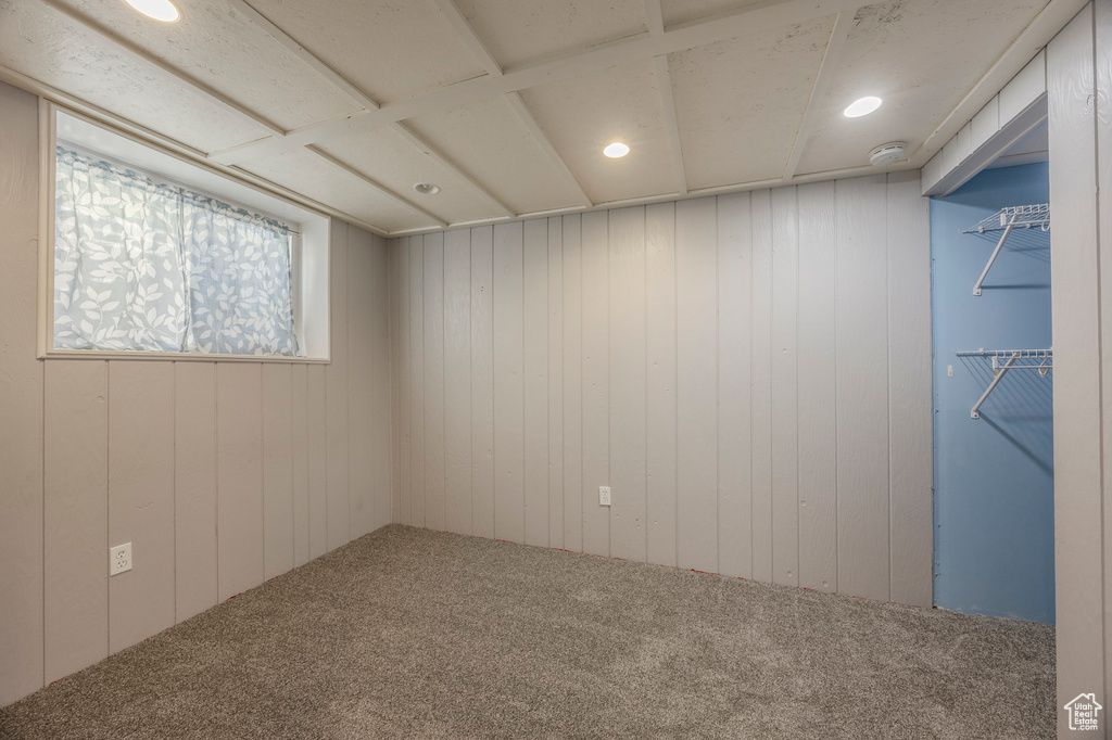 Unfurnished room featuring carpet floors, a smoke detector, recessed lighting, and wood walls