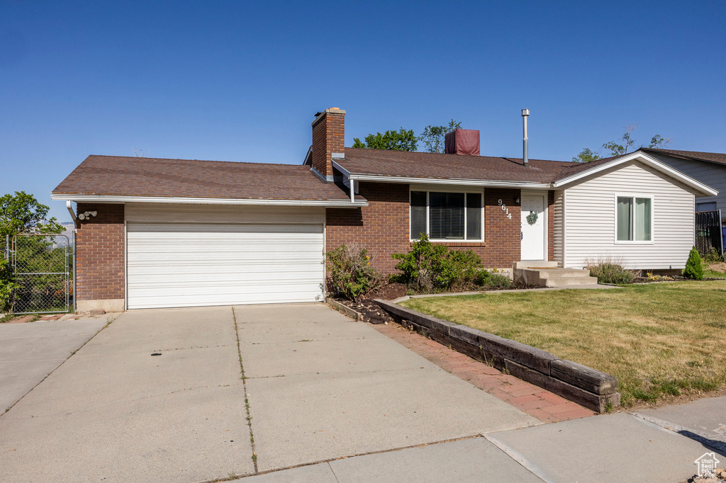 Ranch-style home featuring brick siding, a chimney, concrete driveway, and an attached garage