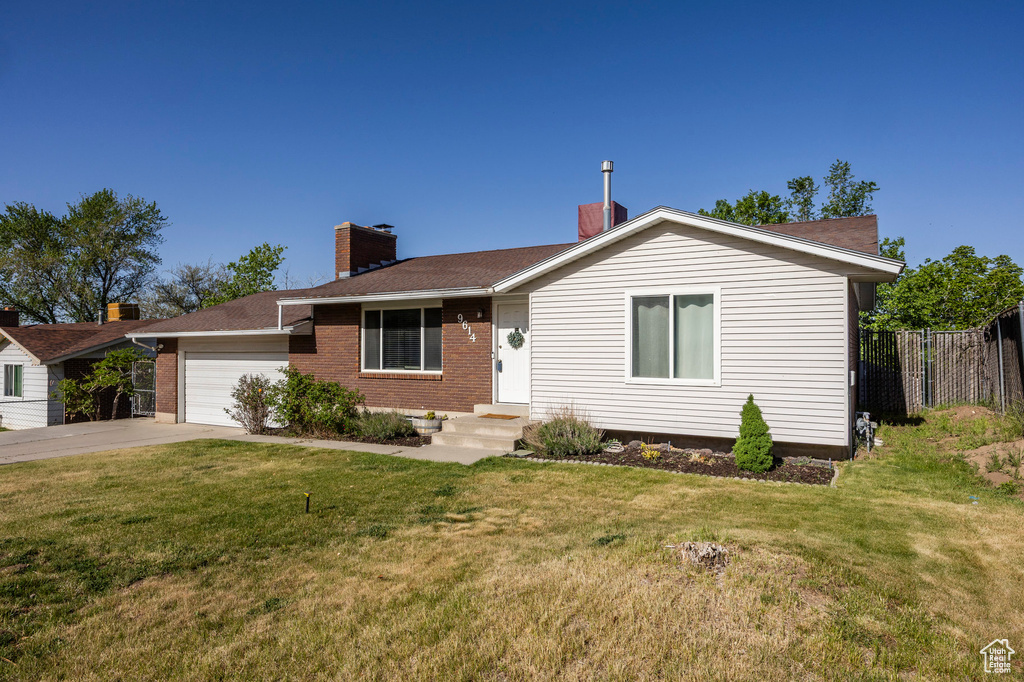 Ranch-style home with a garage, brick siding, driveway, a chimney, and roof with shingles