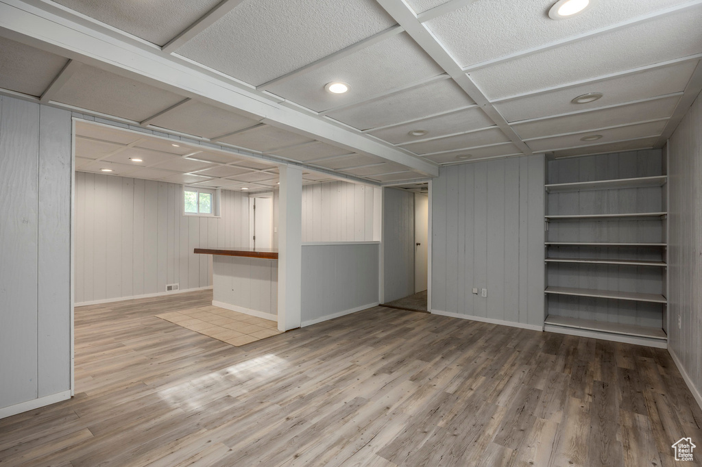 Below grade area featuring wood finished floors, baseboards, and wood walls