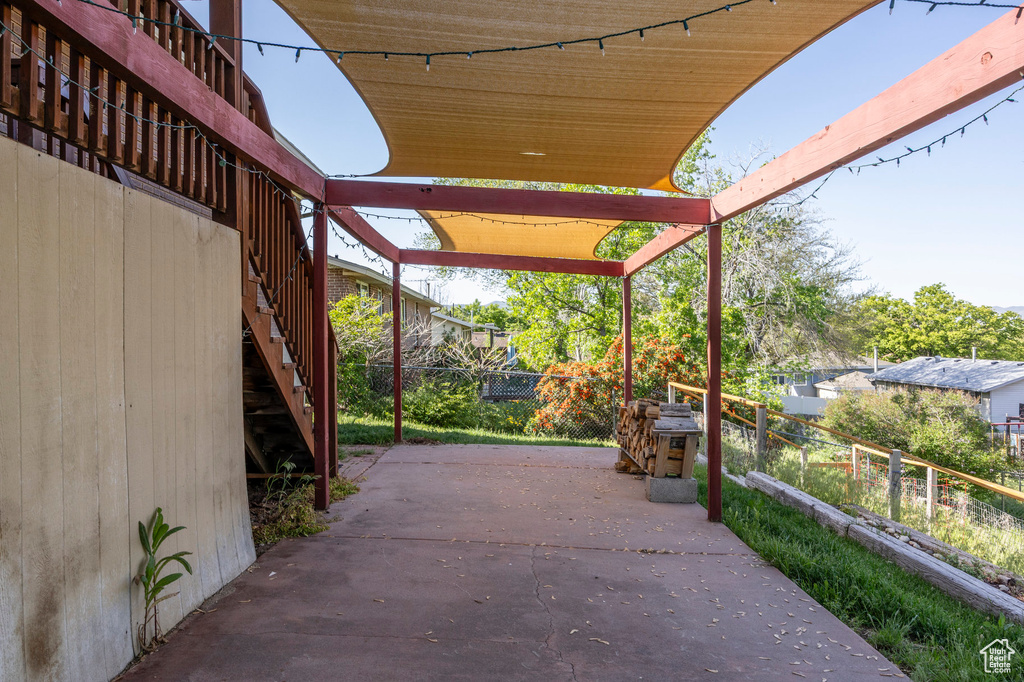 View of patio featuring stairway and fence
