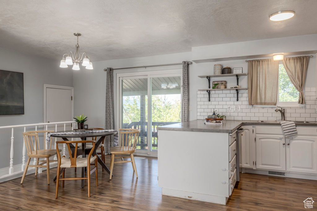 Kitchen with backsplash, dark wood-style flooring, white cabinetry, and open shelves