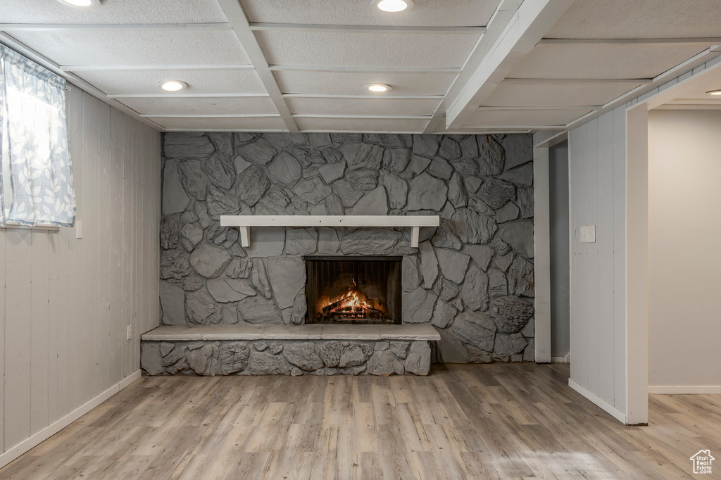 Detailed view of wood finished floors, a fireplace, and baseboards