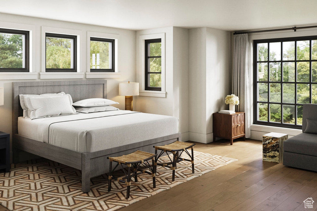 Bedroom featuring multiple windows and wood-type flooring