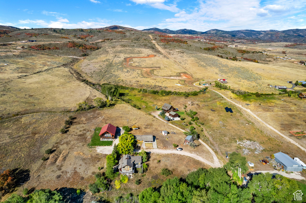 Aerial view of property and surrounding area featuring a mountainous background and rural landscape