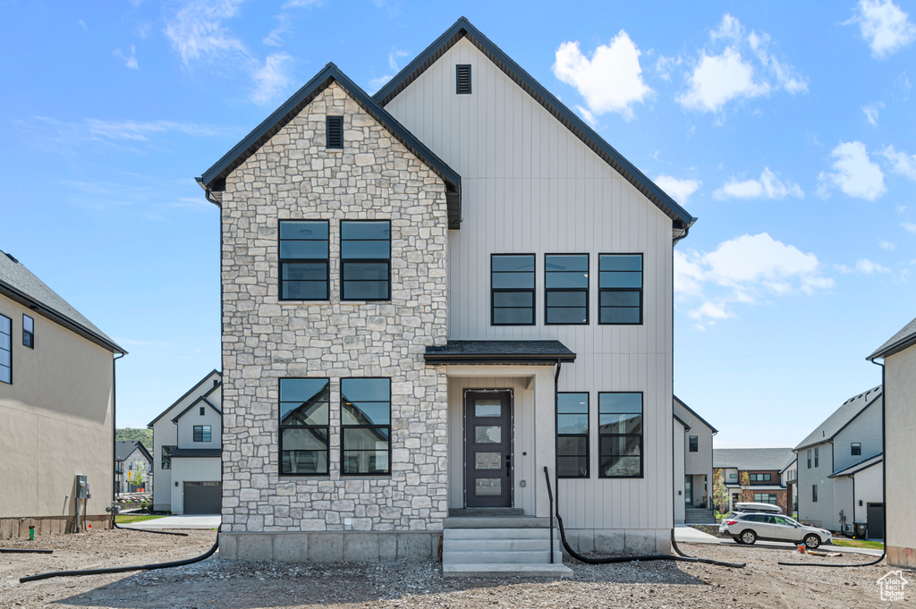 View of front of property with stone siding, board and batten siding, and entry steps
