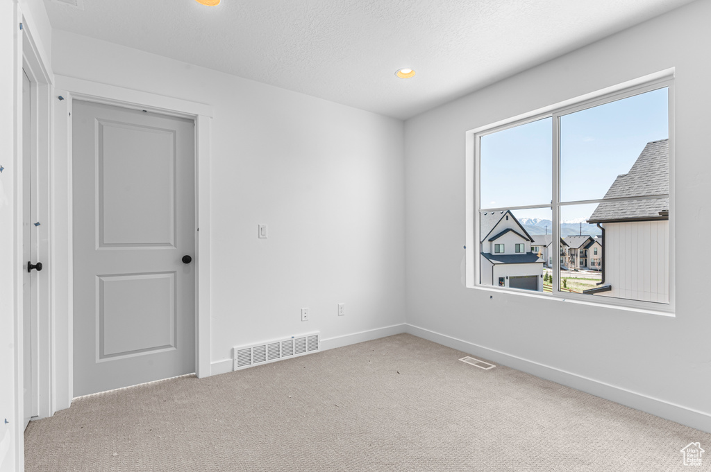 Spare room featuring carpet floors, baseboards, and recessed lighting