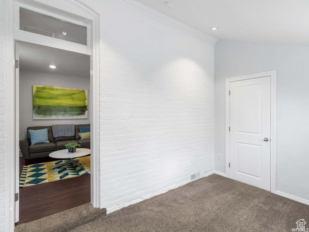 Spare room featuring carpet, ornamental molding, and baseboards